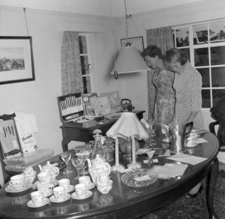 Inspecting the wedding presents. Two women examine wedding presents on display at the Patterson