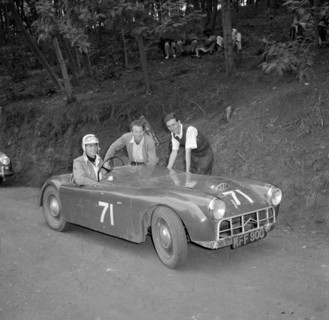 Murdoch drives 'the mouse'. Murdoch sits at the wheel of a sports car nicknamed 'the mouse', posing