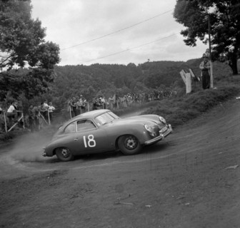 Hofman takes a corner. A Porsche driven by Hofman skids around the corner in event number thirteen