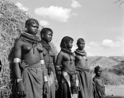 Turkana village girls. Portrait of four young Turkana women and a child outside a thatched village