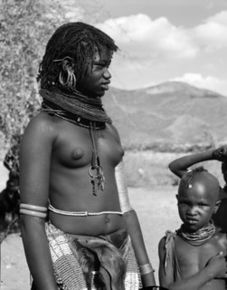 A young Turkana woman. Portrait of a young Turkana woman with a child in shot. Semi-naked, she