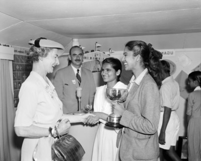 Coats & Clark prize winners. Two Indian girls are awarded trophies by a European Coats & Clark