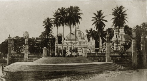 Malaysian mosque. Steps lead up to a decorative, domed mosque surrounded by palm trees. Singapore,