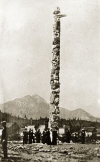 Native American totem pole. Sailors from the British Special Service Squadron stand beneath a