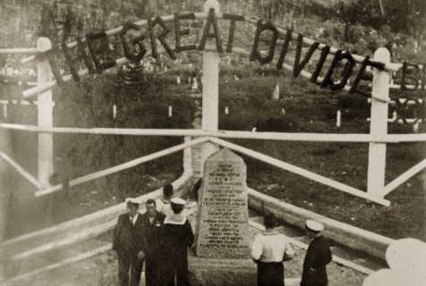 The Great Divide'. Uniformed naval personnel stand beside a stone marker indicating the division