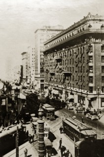San Francisco street scene. American flags fly above a busy city street crammed with tall