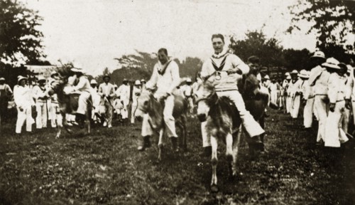 Donkey derby winning post. Uniformed sailors in the British Special Service Squadron entertain