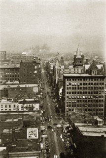 City street in Toronto. View of a busy city street lined with vehicles and crowds of pedestrians.