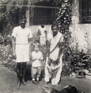 A colonial garden, India. An Indian servant and an ayah (nursemaid) entertain two young British