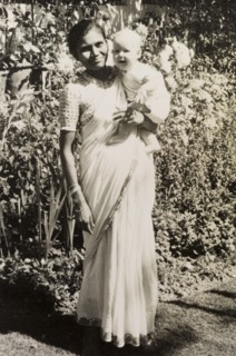 An Indian ayah poses with infant. Dressed in a flowing sari, an Indian ayah (nursemaid) identified