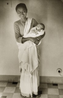 An Indian ayah with infant. Dressed in a flowing sari, an smiling Indian ayah (nursemaid) holds a