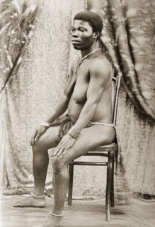 Seated woman with scarified stomach. Portrait of a seated woman, with scarified stomach and wearing