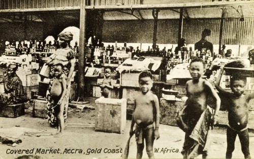 Covered market in Accra. Street traders at a busy covered market in Accra sell bottles from stalls.