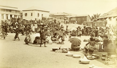 Market at Cape Coast. Street traders shelter under parasols as they sell their wares at the busy