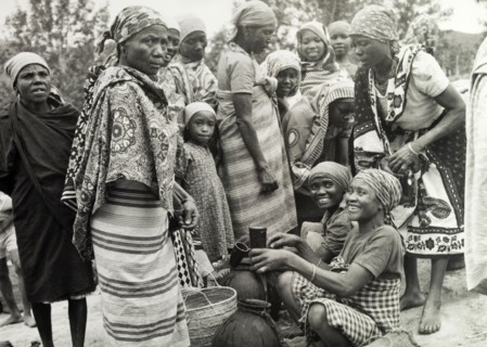 Women at a Tanganyikan market. Women laugh and chat as they examine goods at a local market.