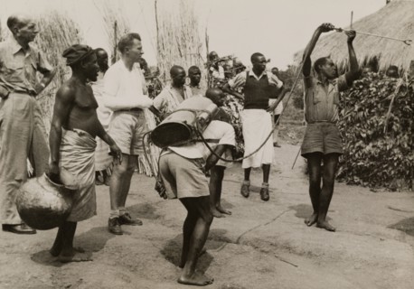 Spraying pesticide at a Congolese village. A team of men use a portable atomiser to spray