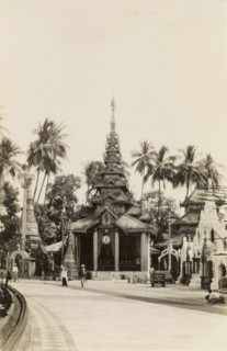 In the grounds of the Shwe Dagon Pagoda. View of a pagoda with a tiered roof and pillared entrance,