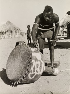Painting a djembe drum. A Tonga (Batonga) man in traditional dress paints a decorative pattern onto