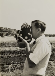 Filming for the Central African Film Unit. A European cameraman operates a movie camera during a
