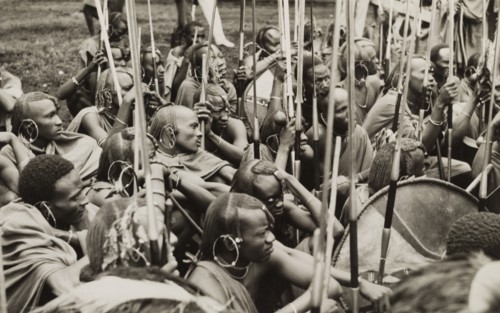 A group of Maasai warriors. A group of Maasai warriors crouch together on the ground with their