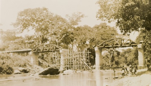 The Ishua to Ibillo bridge. Scaffolding straddles a river beneath an unfinished section of the