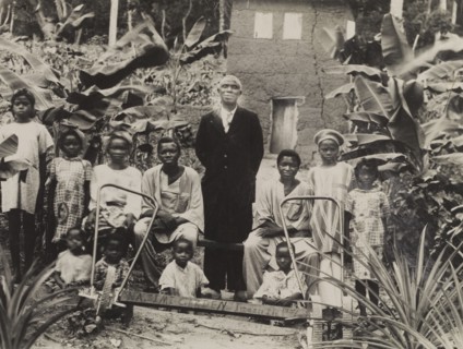 Children in 'Wasimi Garden'. Children gather around an adult male for a group photograph in 'Wasimi