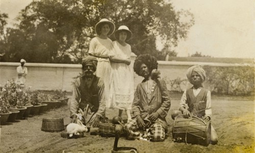 A sacrificial rabbit. Two European women stand fixated, watching as a group of snake charmers