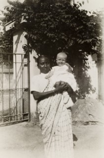 Ayah with baby. An Indian ayah (nursemaid) holds a British baby outside the gates of a colonial