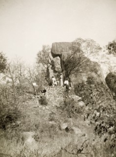 Exploring the Khami ruins. Four European women, wearing sun hats and summer dresses, explore the