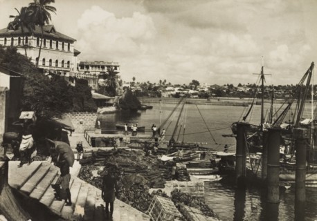 Mombasa Old Port, 1950. View across Mombasa's Old Port showing tradesmen unloading crates from
