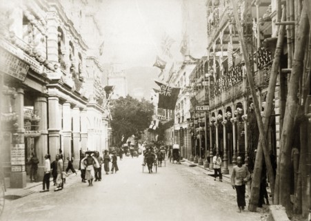 Queen's Road Central, Hong Kong. Rickshaws, pedestrians and street traders bustle about on Queen's