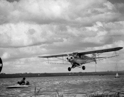 Airspray demonstration. A small plane flies low over the water at the Aquasports Regatta. Kenya, 28
