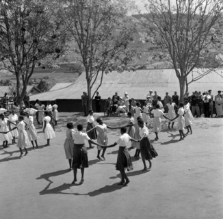 Schoolgirls dance for Princess Margaret. Princess Margaret and her entourage watch a group of