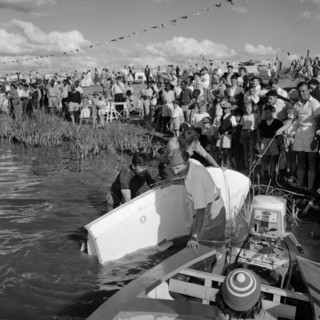 Landing stage at the Aquasports Regatta. Crowds at the Aquasports Regatta watch as three men stand
