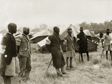 Kikuyu Home Guards in camp. Six Kikuyu Home Guards, dressed in makeshift uniforms and armed with