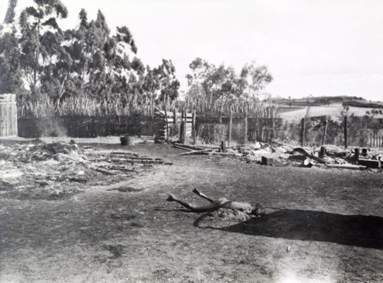 Child murdered by Mau Mau. The body of a murdered child lies rigid in the smoking ruins of a