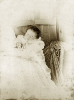 Cubbo' at two weeks, Australia. Portrait of a young baby dressed in a white gown, originally