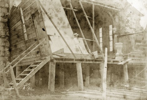 Destruction of a temporary church. A man takes notes inside the ruins of a wooden church