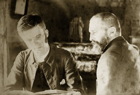 Thomas St John Parry Pughe and friend. Reverend Thomas St John Parry Pughe examines a book in the