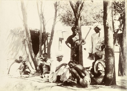 Indian street barbers. Turbaned Indian men sit on rugs in the street, providing a barber service