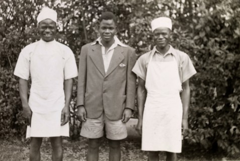Domestic servants. Three domestic servants in workwear smile for the camera, their roles identified