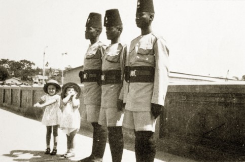 Barbara and Gwynneth with askaris. Two small European girls, Barabara and Gwynneth Wallhouse, pose
