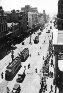 Adderley Avenue, Cape Town. Flower sellers line the pavement of a busy city street dotted with
