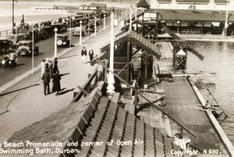 The beach promenade at Durban. Groups of people stroll along the beach promenade in Durban beside