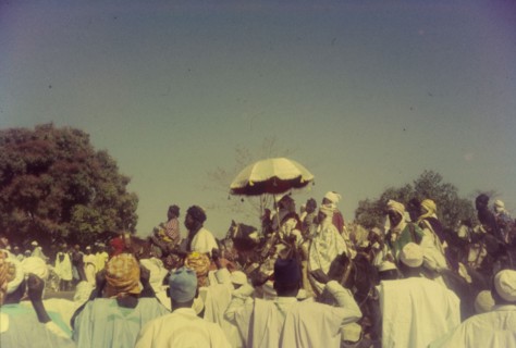 The Emir of Zaria. The 'Sarkin Zazzau' (Emir of Zaria), Alhaji Shehu Idris, is protected from the