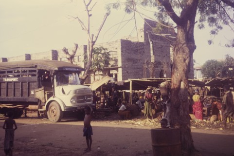 Market outside a damaged church. Street traders set up their stalls outside the remains of church