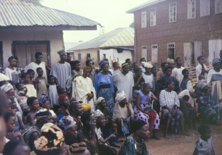 An audience of onlookers. A crowd of spectators are captivated by a performance happening just out
