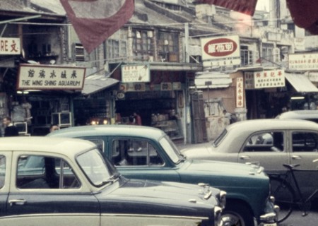 Street in Kowloon. A line of cars is parked outside shopfronts on a street in central Kowloon.