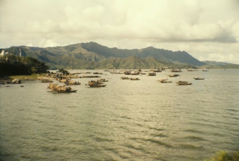 Fishing boats off Tai Po. Mountains form a backdrop to a fleet of Chinese sampans that bob up and