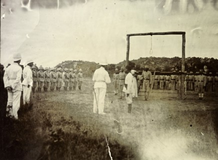 Governor reads death sentence. A European official reads a death sentence, facing a large wooden
